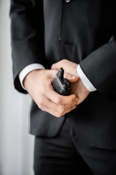 Surveillance, cropped view of bodyguard standing with walkie talkie, man in black suit, hotel safety, security management, uniformed guard on duty, professional headshots — Stock Photo
