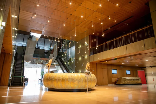 Intérieur moderne de l'hôtel avec réception ronde et design sophistiqué dans le hall, escaliers mécaniques, escalier mobile, ambiance luxueuse, spacieuse et confortable, chic et chic — Photo de stock