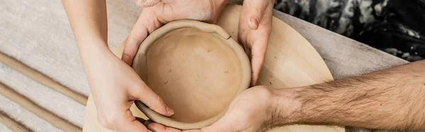 Обрезанный вид на пару ремесленников, делающих глиняную чашу в керамической мастерской, баннер — стоковое фото