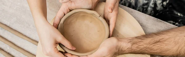 Cropped view of couple of artisans making clay bowl in ceramic workshop, banner — Stock Photo