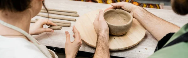 Cropped view of romantic couple molding clay while working in ceramic workshop, banner — Stock Photo