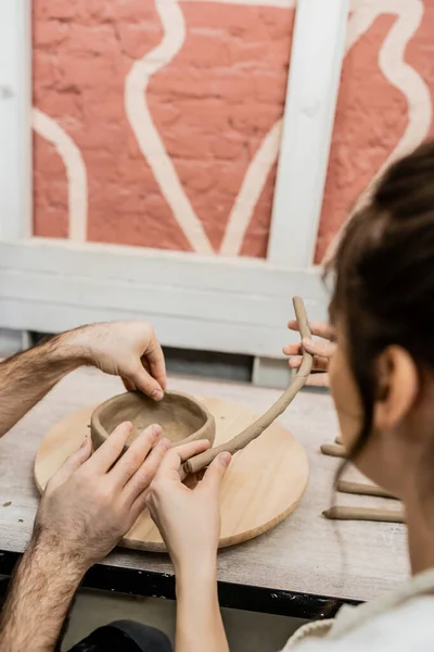 Romantic couple of artisans shaping clay earthenware on wooden board in ceramic studio — Stock Photo