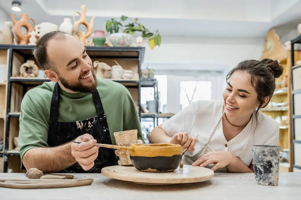 Sorrindo casal romântico de artesãos em aventais trabalhando juntos no estúdio de cerâmica, banner — Stock Photo