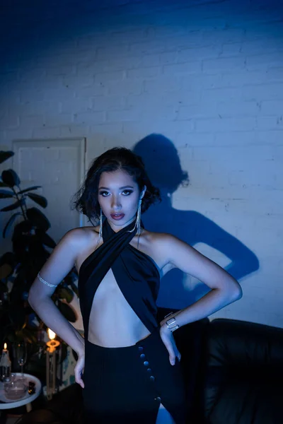 Confiant et élégant asiatique femme regardant caméra en néon éclairage dans la boîte de nuit — Photo de stock