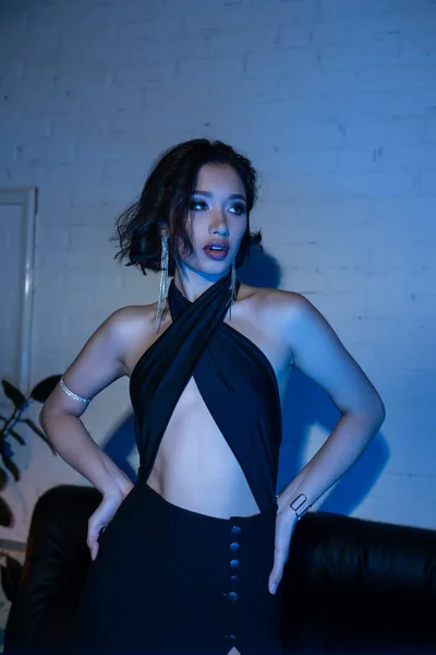 Bella giovane donna asiatica in abito sexy in piedi in night club con illuminazione al neon — Foto stock