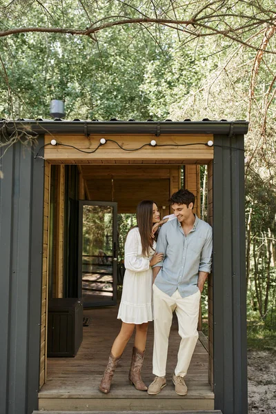 Bel homme et femme en robe de soleil debout près de la maison de vacances, amour et romance, couple heureux — Photo de stock