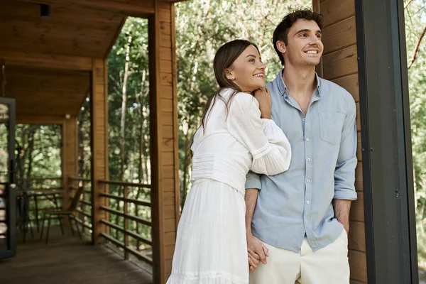 Happy man standing with hand in pocket near beautiful woman in sundress, summer house, vacation — Stock Photo