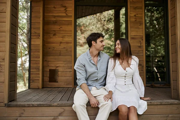 Couple heureux assis sur le porche, maison de vacances, romance d'été, homme et femme passer du temps ensemble — Photo de stock