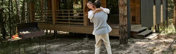 Banner, glücklicher Mann hebt fröhliche Frau mit Tätowierung, Ferienhaus im Wald, Sommerurlaub — Stockfoto