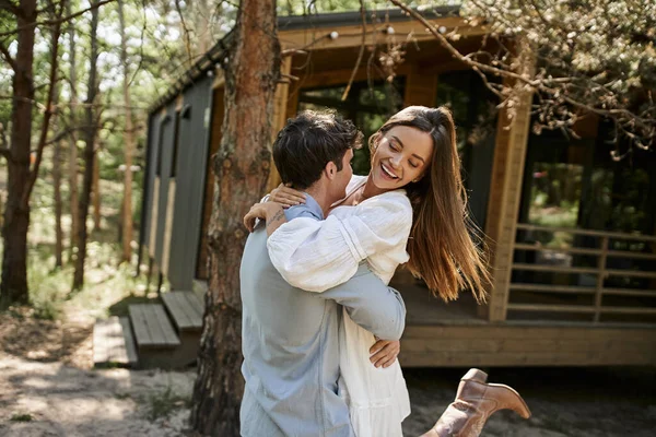 Летняя радость, счастливая женщина обнимая с парнем возле дома отдыха в лесу, любовь, романтическая пара — стоковое фото