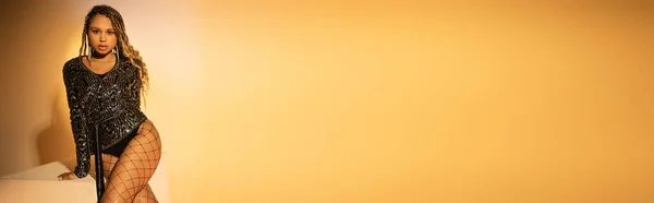 Баннер, африканская американка в сексуальных трико рыболовная сетка позирует на желтом фоне, посмотрите на камеру — стоковое фото
