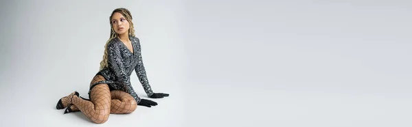 Bannière, de la mode, modèle afro-américain assis sur fond gris, tatouage et gants, femme noire — Photo de stock