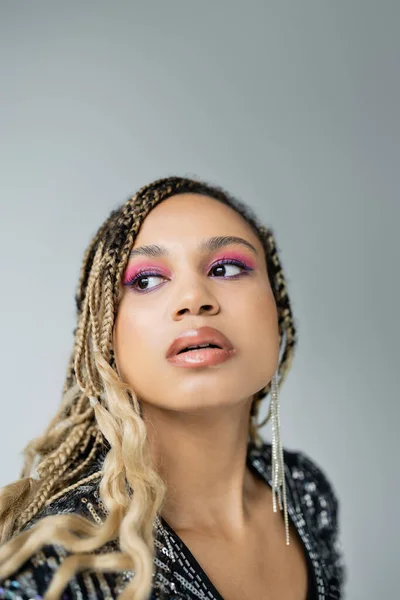 Bonita mujer afroamericana con maquillaje audaz posando sobre fondo gris, mirando hacia otro lado, la moda — Stock Photo