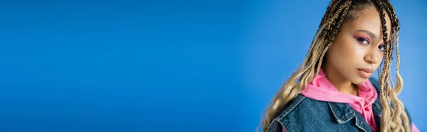 Banner, schöne afrikanisch-amerikanische Frau mit Dreadlocks schaut in die Kamera auf blauem Hintergrund — Stockfoto