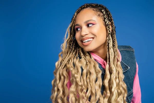 Beautiful african american woman with dreadlocks and long hair looking away on blue background — Stock Photo