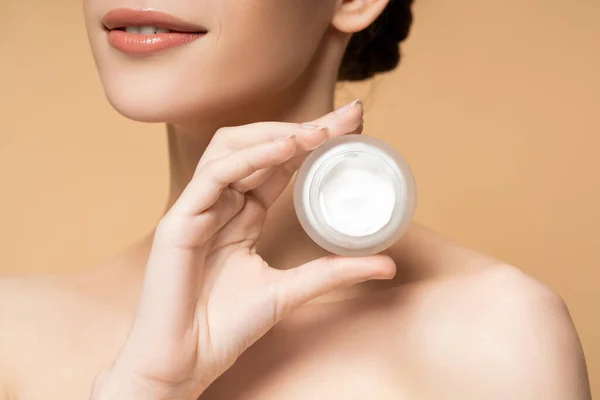 Vista ritagliata di giovane donna sorridente con spalle nude con crema cosmetica isolata sul beige — Foto stock