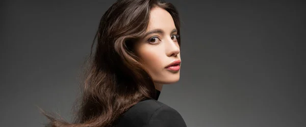 Selbstbewusstes junges asiatisches Model mit Make-up posiert in schwarzer Jacke isoliert auf grau, Banner — Stockfoto