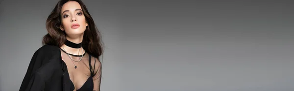Elegante ásia mulher com maquiagem posando no topo e jaqueta enquanto de pé isolado no cinza, banner — Fotografia de Stock