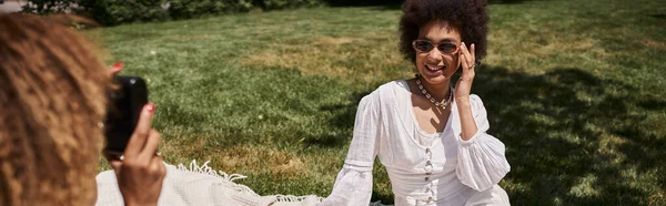 Donna afroamericana con fotocamera vintage scattare foto di fidanzata felice nel parco estivo — Foto stock