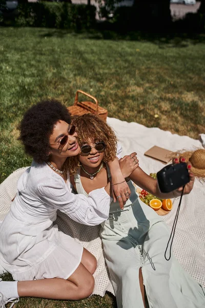 Afro americano donna abbracciare fidanzata prendere selfie su vintage fotocamera, estate tempo libero — Foto stock
