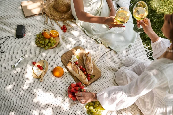 Vista superior, picnic, novias afroamericanas con copas de vino cerca de frutas, verduras, pan - foto de stock