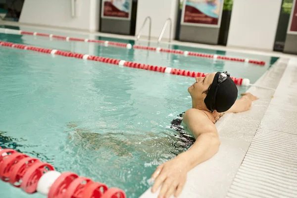 Mulher de meia-idade relaxante à beira da piscina, touca de natação e óculos, esporte, estilo de vida saudável, tranquilo — Fotografia de Stock