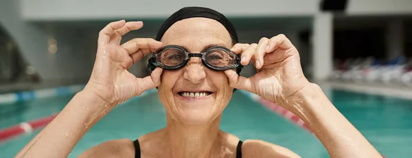 Happy woman in swim cap wearing goggles, positive, swimming pool, recreation center, tattoo, banner — Stock Photo