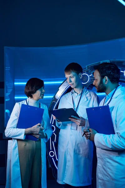 Two scientists and an intern collaborate at a futuristic research center — Stock Photo