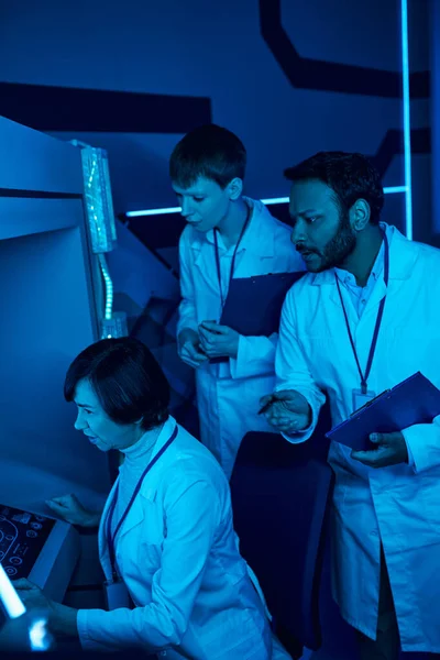 Esplorare domani: Tre scienziati collaborano con il computer futuristico vicino al centro scientifico — Foto stock
