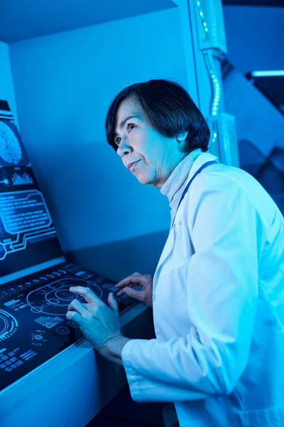 Competenza futuristica: scienziata anziana impegnata vicino al computer nel futuro centro scientifico — Foto stock