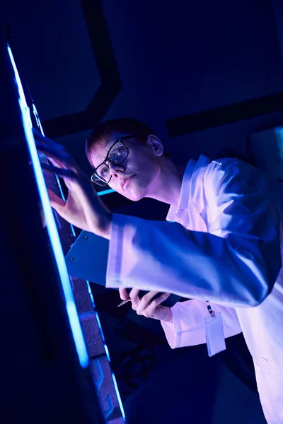 Conceito futurista: jovem estagiário explorando dispositivo experimental no centro de inovação — Fotografia de Stock