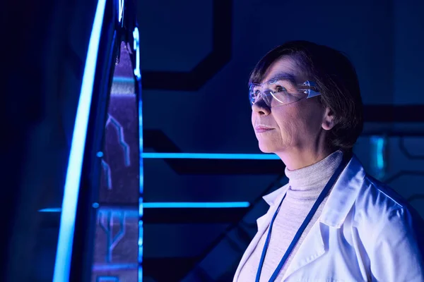 Laboratório futurista, mulher cientista de meia idade em óculos examinando equipamentos experimentais — Fotografia de Stock