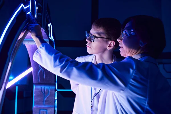 Wissenschaftliche Entdeckung, Wissenschaftlerin und junge Praktikantin erkunden Gerät in Discovery Center — Stockfoto