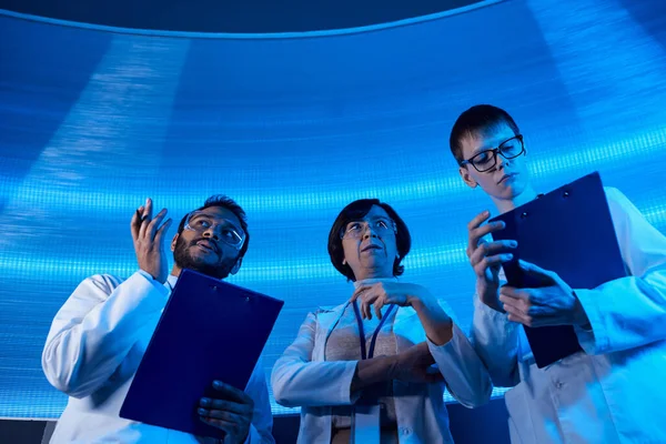 Индийский ученый с руками рядом с коллегами в научном центре, ориентированный на будущее — стоковое фото