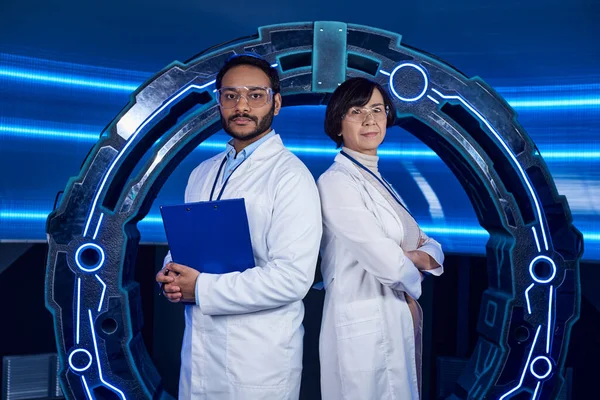 Forward-thinking multiethnic scientists looking at camera back to back in innovation hub — Stock Photo