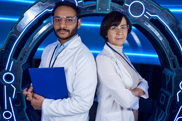 Forward-thinking multiethnic scientists standing looking at camera back to back in discovery center — Stock Photo