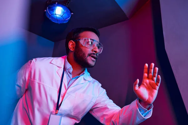 Exploração futura, cientista indiano preocupado olhando afastado na luz do néon no hub da inovação — Fotografia de Stock