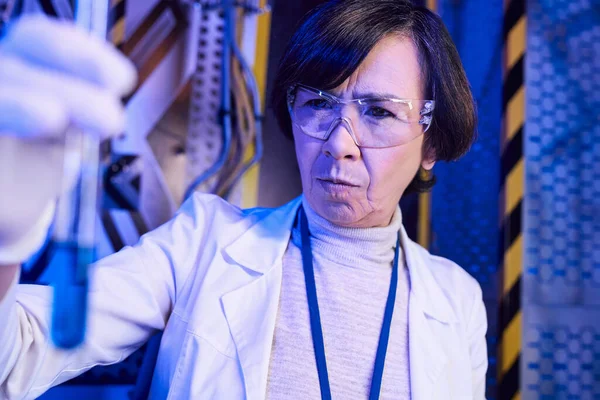 Pesquisa de vida alienígena, cientista mulher em óculos olhando para amostra em tubo de ensaio no centro de ciências — Fotografia de Stock