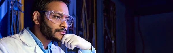 Científico indio reflexivo en gafas y guantes de látex en el centro de ciencia, pensamiento creativo - foto de stock