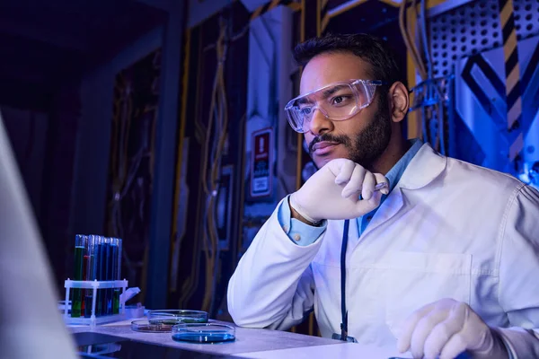 Досліджує інопланетне життя, індійський вчений в окулярах біля посуду Петрі та пробірки, центр відкриттів — стокове фото