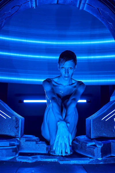 Innovation Hub, außerirdischer humanoider Außerirdischer sitzt in experimentellem Hub im Neonlicht — Stockfoto