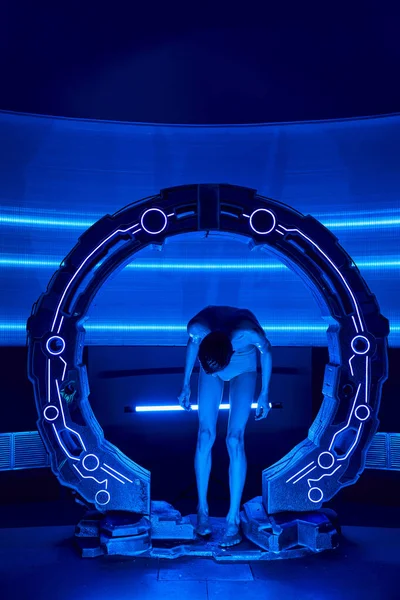 Exploración científica, humanoide alienígena mirando las piernas en el dispositivo experimental en el centro de descubrimiento - foto de stock