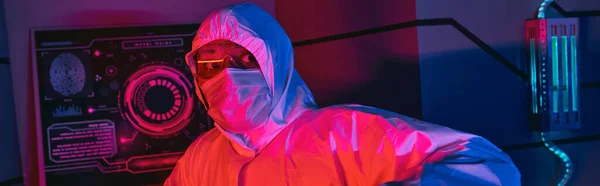 Индийский ученый в защитном костюме, очках и медицинской маске, смотрящий в научный центр, баннер — стоковое фото