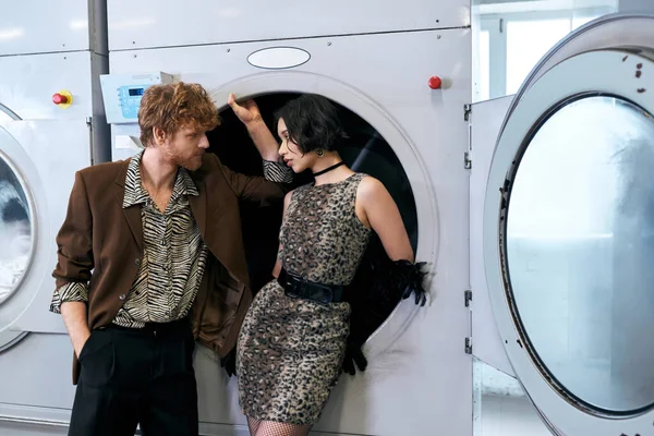 Moda jovem casal interracial olhando uns para os outros na lavanderia pública — Fotografia de Stock