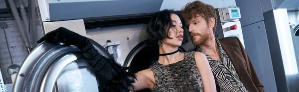 Trendy giovane coppia interrazziale in posa uno accanto all'altro in lavanderia pubblica, banner — Foto stock