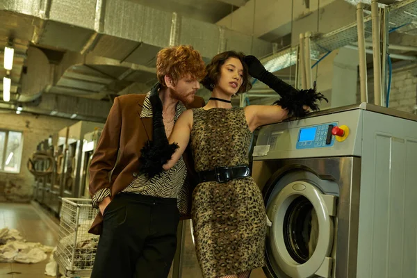 Sexy and stylish young man flirting with asian girlfriend in dress in public laundry — Stock Photo