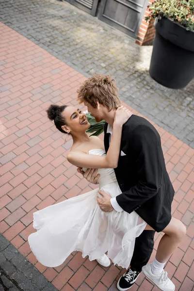 Любов у місті, елегантна багатоетнічна пара обіймається на вулиці, радість, щастя — стокове фото