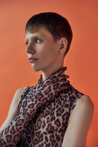 Queer person, fashion concept, young man posing on orange backdrop, animal print, leopard print — Stock Photo