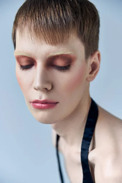 Retrato, modelo andrógino com maquiagem, fundo cinza, beleza e visagem, bicha, close — Fotografia de Stock