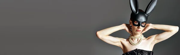 Persona queer in corsetto e nero bdsm maschera coniglietto su grigio, androgino, moda, posa, banner — Foto stock